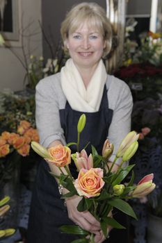 Florist picking flowers from her shop to make a bouquet