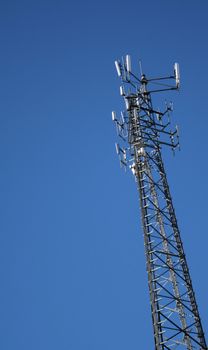 A cell phone tower set against a blue sky background.
