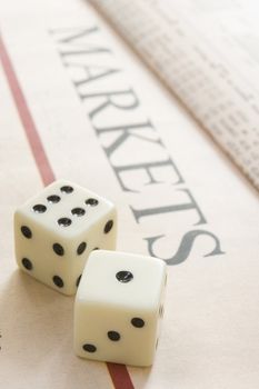 pair of dice resting on a paper with the headline Maekets