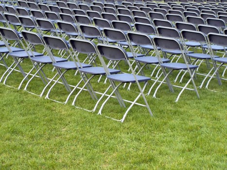 Chairs lined up on the summer lawn in preparation for a celebration.