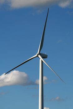 A close up of wind turbine shot against a blue sky.
