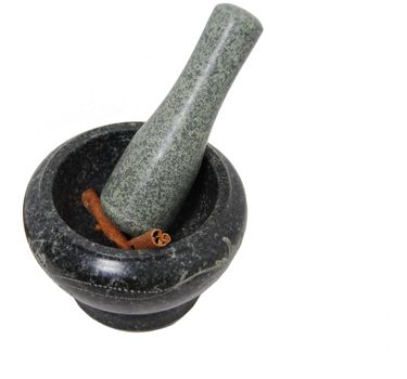 Sticks of cinnamon are being ground by mortar and pestle.