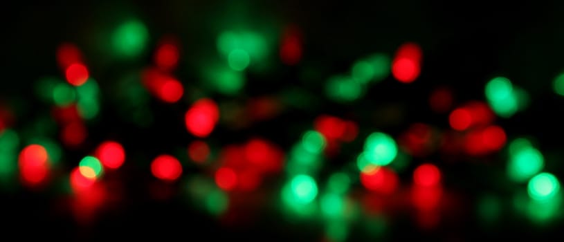 Red and green Christmas lights, blurred to create a holiday background. 