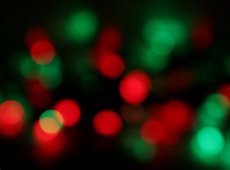 Red and green Christmas lights, blurred to create a holiday background.
