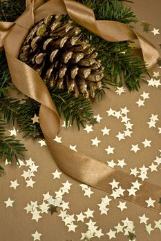 christmas decoration with tree, cone and stars on gold background