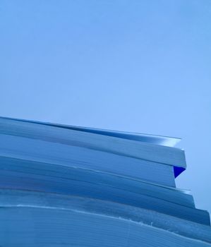 Blue tinted closeup shot a pile of books with copy space