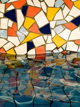 Fountain wall closeup with colorful tiles reflecting in water