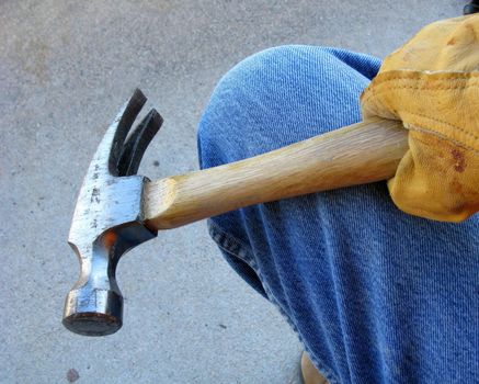 Construction worker with gloved hand holding tool against a white background.