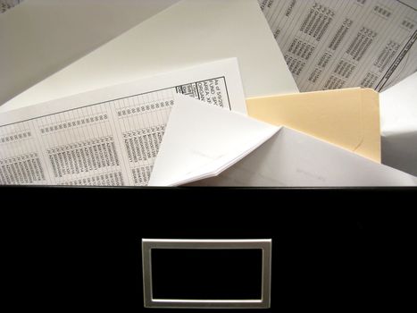 Overflowing messy office filing cabinet drawer spills spreadsheets and other documents.