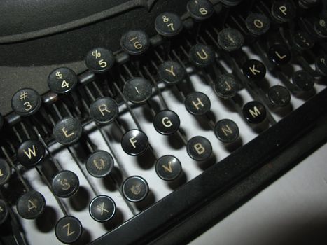 Closeup of keys on a battered vintage manual typewriter.