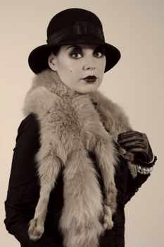 Retro styled fashion portrait of a young woman. Clothing and make-up in twenties style.