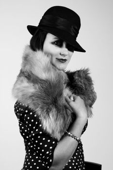 Retro styled fashion portrait of a young woman. Clothing and make-up in twenties style.