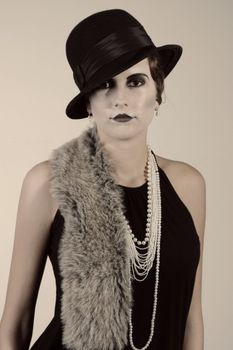 Retro styled fashion portrait of a young woman. Clothing and make-up in twenties style.