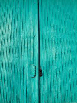 Turquoise wooden entrance door with chain