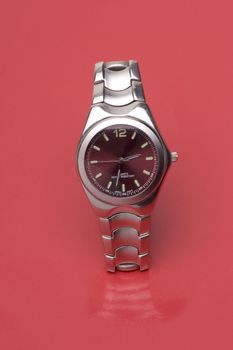 Men sport watch on red reflective surface