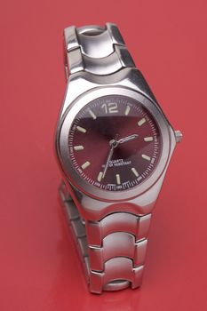 Men sport watch on red reflecting surface