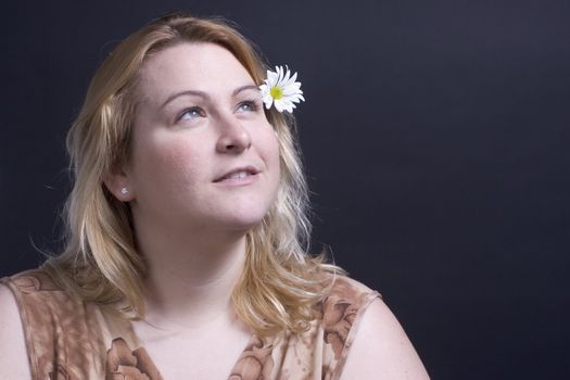 Women looking up at the heaven thinking about the flower in her hair