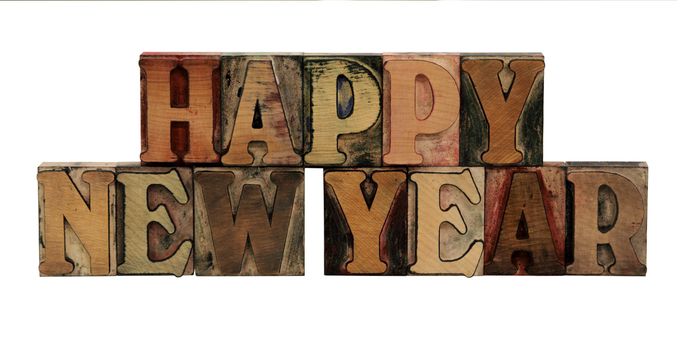 Happy New Year in letterpress wood letters in all caps isolated on white