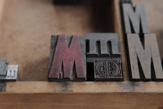 the letter M in upper and lower case and different fonts, both serif and san serif, all in a wood type case