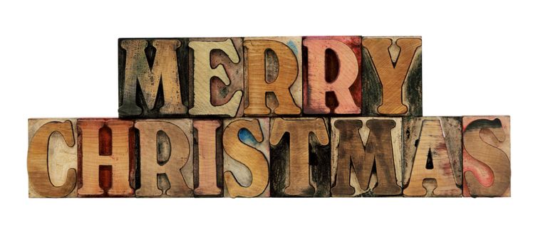 Merry Christmas in old, ink-stained letterpress wood type, all caps, isolated on white