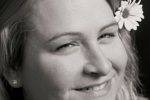 Close up of a women smiling with a flower in her hair