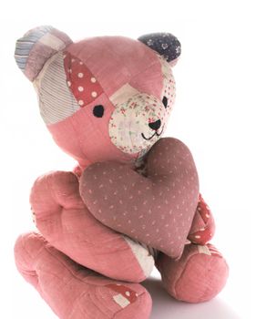 teddy bear made from antique quilts holding a large mauve calico heart