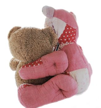 a patchwork quilted teddy bear hugs a plush brown bear in a comforting manner