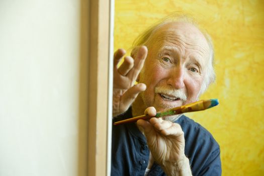 Elderly painter working on a large canvas