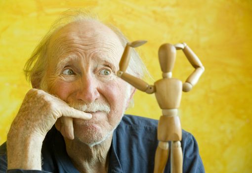 Elderly Artist Ponders a Wooden Figure Model