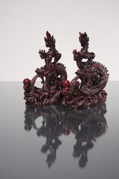 Twow dragon statue racing over reflecting surface