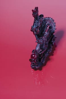 Chinese dragon statue on red background with reflection