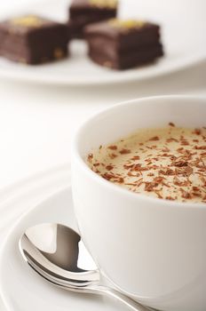 Coffee cup with cream and chocolate cakes