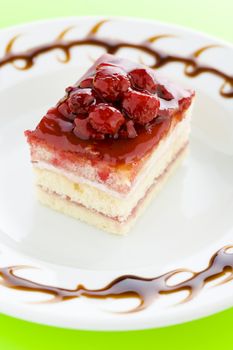 Piece of raspberry cake on the plate with chocolate dressing