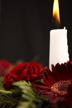 Candles with flower setup on the brown table over black background