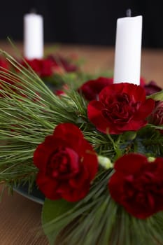 Candles with flower setup on the brown table over black background