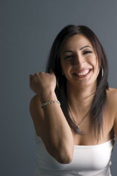 Twenty something fashion model in white tube top, showing bracelet or making a rude gesture laughing