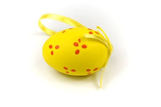 One yellow easter egg with gold ribbon isolated on white