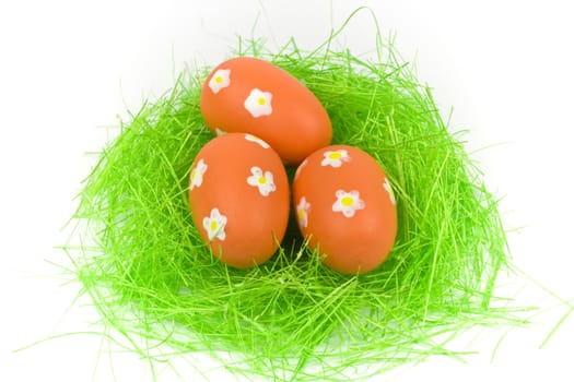 Three red easter eggs with green grass isolated on white