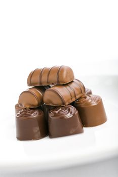 Pile of chocolate assortment on the white plate