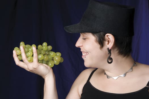 Thirty something model eating green grapes