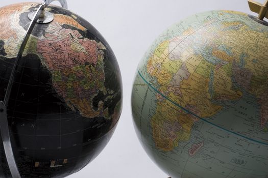 A dark globe showing america facing a light globe showing africa