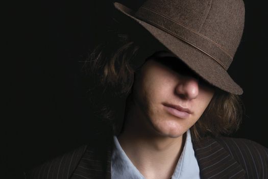 Young man faces partly hidden by hat