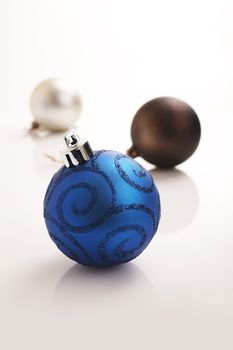 Colored christmas balls on the reflective white background
