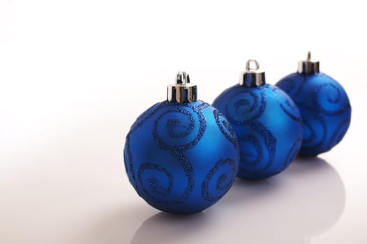 Colored christmas balls on the reflective white background