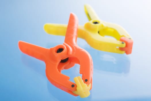 Plastic clamps over a blue reflective background