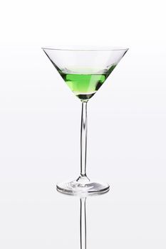 Green cocktail on white mirror like surface with clipping path