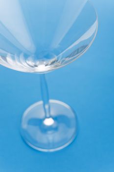 Close up of a empty cocktail glass over a blue background