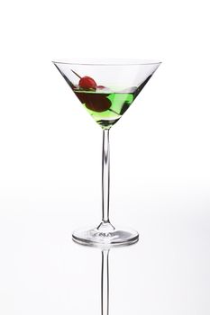 Green cocktail on white mirror like surface with clipping path