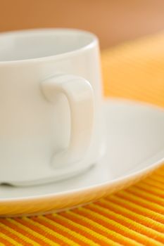Empty coffee on orange - yellow striped fabric 