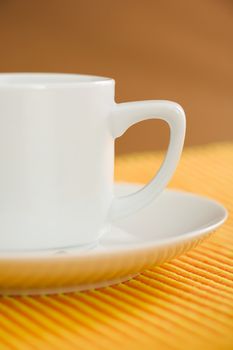 Empty coffee on orange - yellow striped fabric